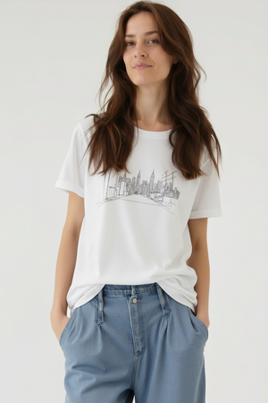 Woman wearing a white t-shirt with a graphic design on a plain background